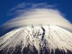 женщина-гора с облаком в небе и покрытым снегом пиком