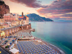 на нем есть пляж с зонтиками и стульями