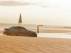 на пляже рядом с водой едет голубой автомобиль