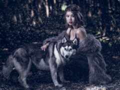 женщина в шубе обнимает хаски-собаку