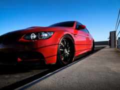 красная женщина припарковалась на улице с голубым небом на заднем плане