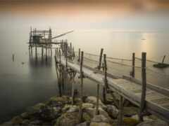 есть пирс, который находится рядом с водой с лодкой на расстоянии