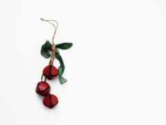 два красных колокола висят на зеленой ленте