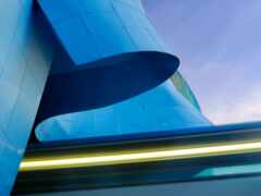 женский вид на синее здание с изогнутым окном