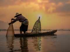 человек на лодке с сетью в воде