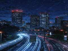 ночной городской горизонт с огнями и движением по оживленной автомагистрали