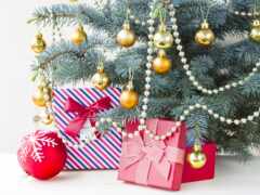 под рождественским деревом много подарков с украшениями
