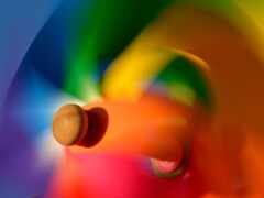 ярко окрашенная вращающаяся игрушка с деревянным шариком в центре