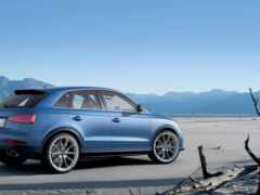 женщина синий audi suv припаркована на пляже с горами на заднем плане