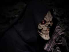 скелет женщины в капюшоне с ножом в руке