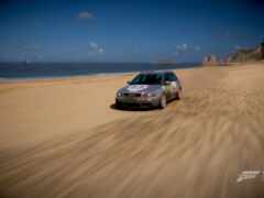 женщина за рулем автомобиля на песчаном пляже возле океана