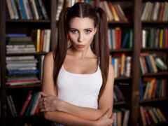 женщина стоит перед книжной полкой с книгами