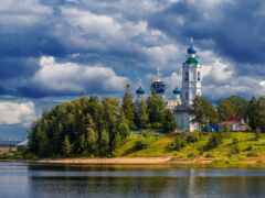 облачное небо над озером и церковью на холме