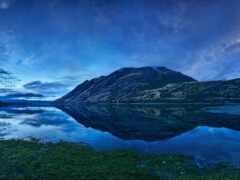 звездное небо над горным хребтом, отражающимся в озере