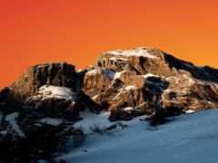 горы, покрытые снегом и сноубордисты на склоне