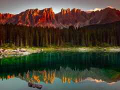 горы, отраженные в озере на закате с бревном на переднем плане