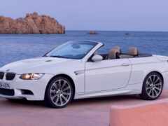 арафированный белый кабриолет bmw припаркован на бетонном выступе возле океана