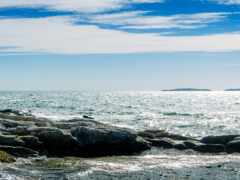 человек стоит на скале у воды