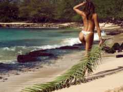 на пляже гуляет женщина в бикини