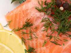 есть кусок лосося с лимонными ломтиками и травами