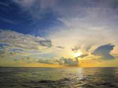 арафляйный выстрел заката над океаном с лодкой вдалеке