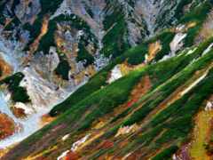 горы с рекой, протекающей через них, и зеленый склон холма