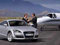 мужчина пожал руку мужчине в костюме рядом с серебряной машиной