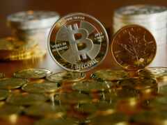 монеты разбросаны по столу с биткойном сверху
