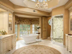 есть большая ванная комната с ванной и люстрой