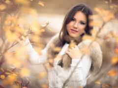 женщина в белом пальто и меховом воротнике позирует для фото