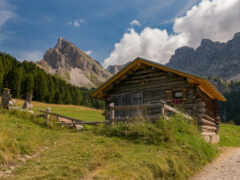 на холме есть небольшая хижина с горой на заднем плане
