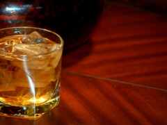 на столе со льдом сидит стакан алкоголя