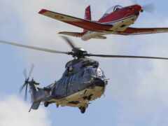 два вертолета, летящие в воздухе с пропеллерами расширены