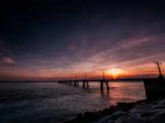 женщина видит мост над водоемом на закате