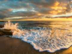 женский вид на пляж с волнами, разбивающимися на берегу