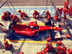 красный гоночный автомобиль, над которым работает механик