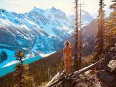 арафы, стоящие на скале с видом на горное озеро и покрытые снегом горы