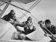 мужчина сидит на крыле самолета с картой