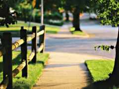 есть деревянный забор вдоль тротуара в парке