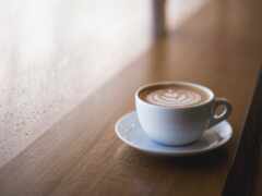 есть чашка кофе на блюдце на столе