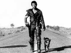 мужчина идет по дороге с собакой на поводке