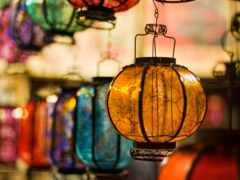 есть много красочных стеклянных фонарей, свисающих с потолка