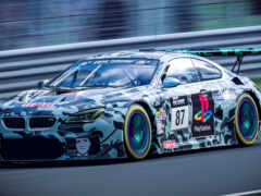 женщина bmw гоночный автомобиль на гоночной трассе с размытым фоном