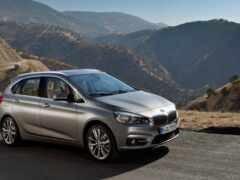 вид на серебристую bmw 2 серии, припаркованную на горной дороге