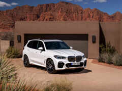 арафед белый bmw suv припаркован перед домом