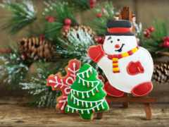 есть снеговик и рождественское дерево, украшенное печеньем на столе