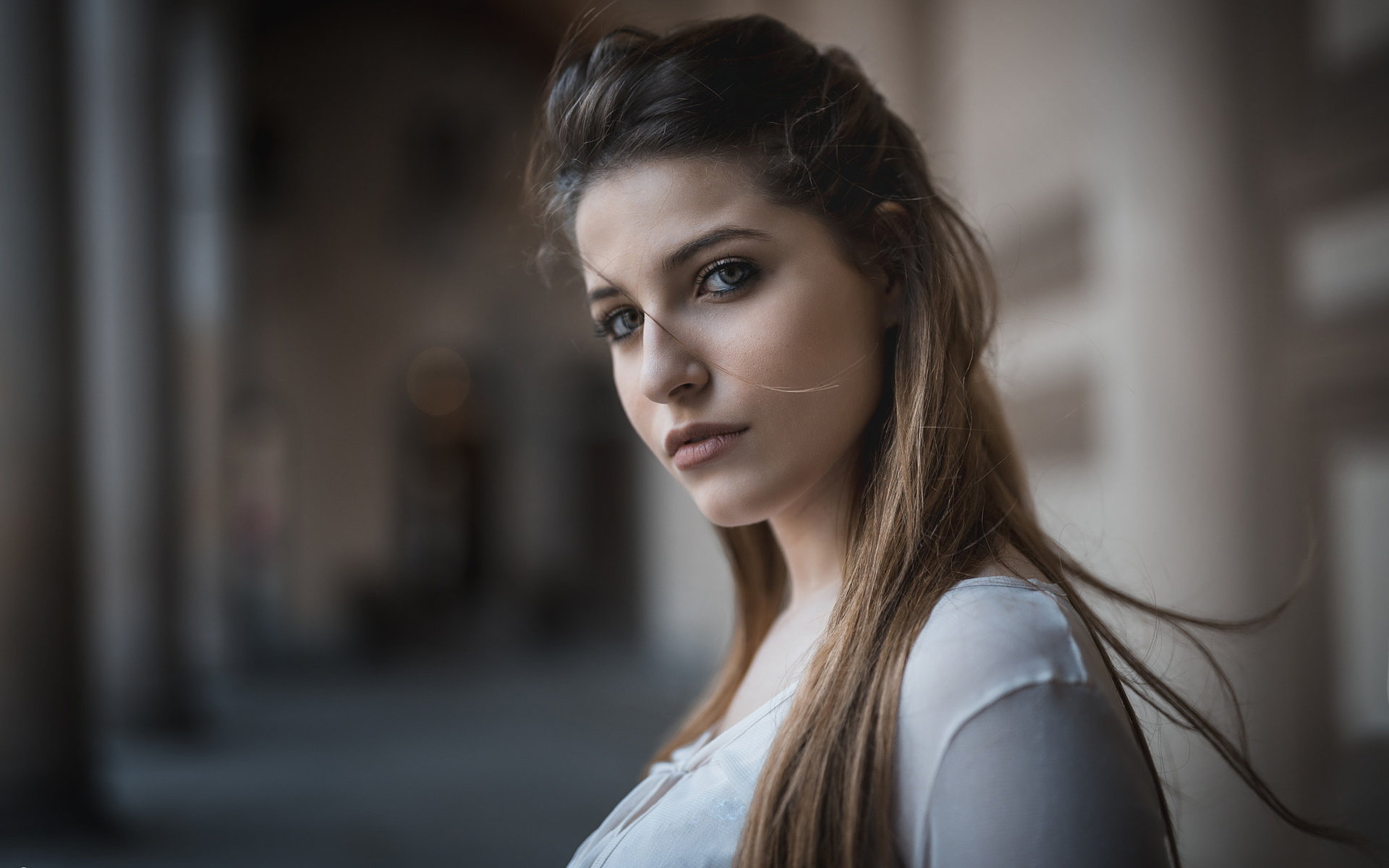 в здании стоит женщина с длинными волосами