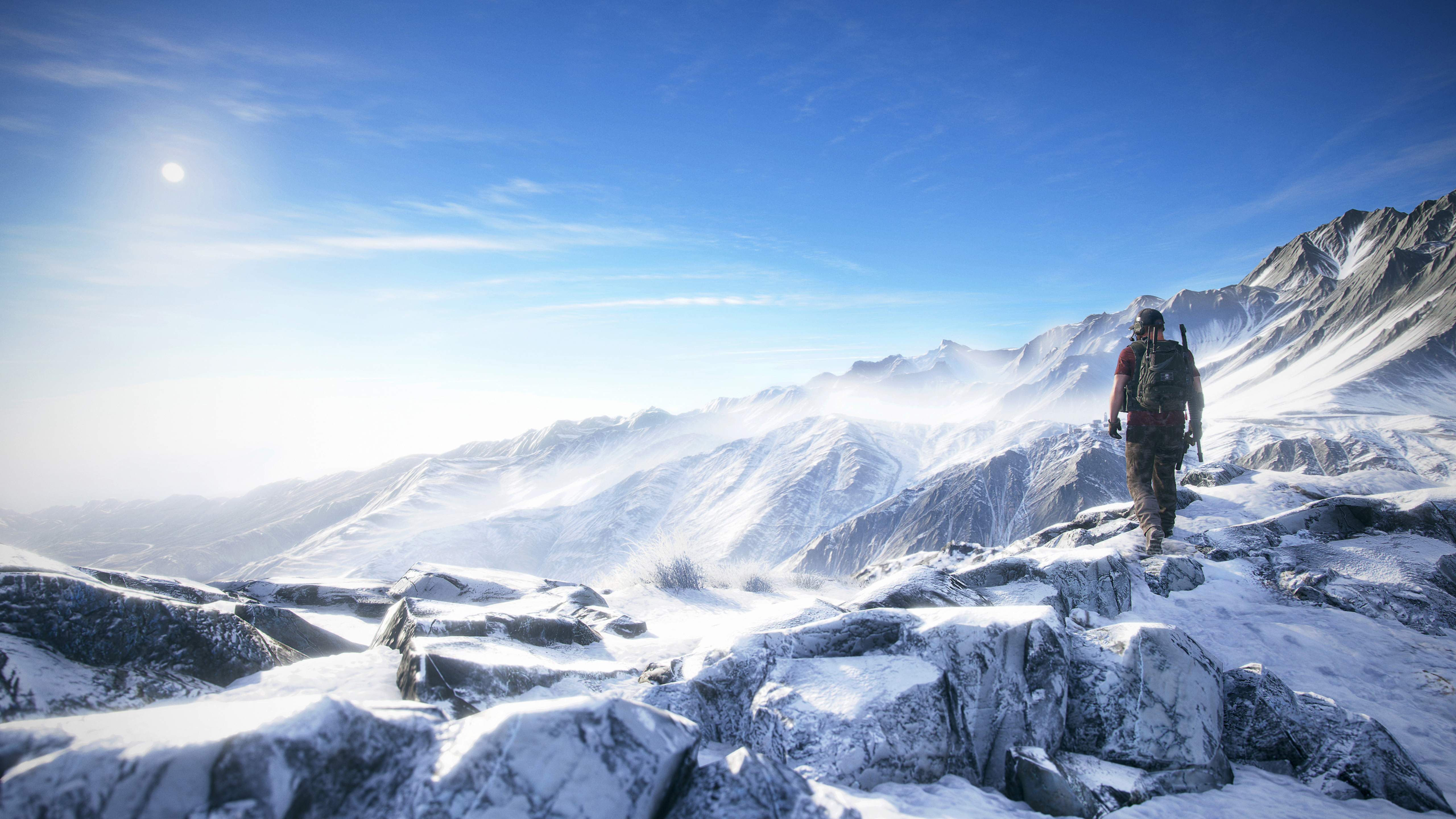 на вершине горы стоит человек со сноубордом