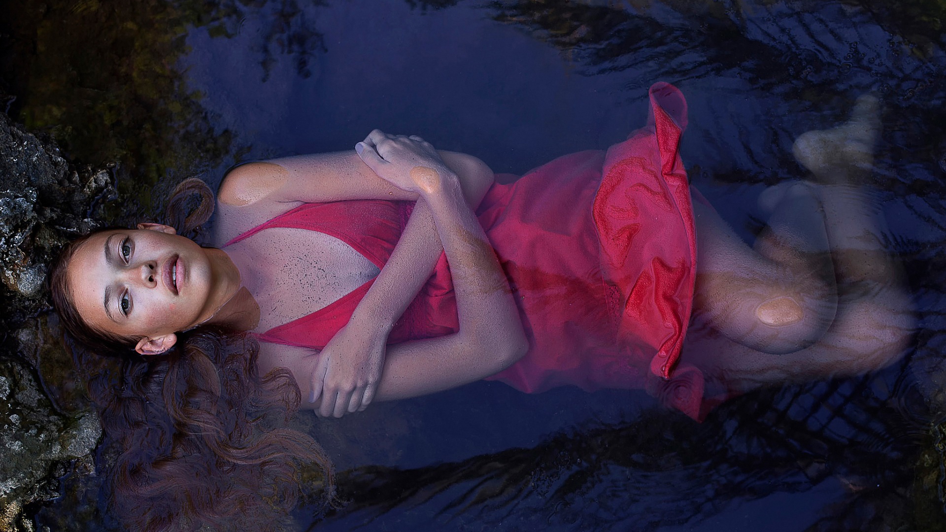 женщина в красном платье лежит в воде