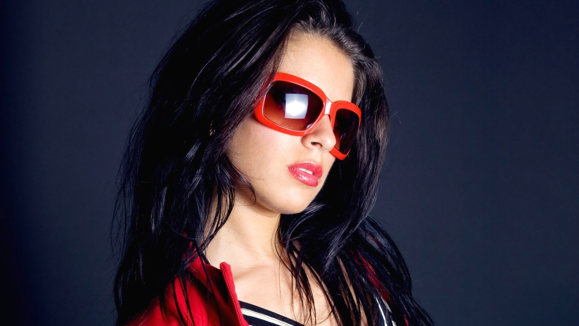 есть женщина в красных солнцезащитных очках и красной куртке